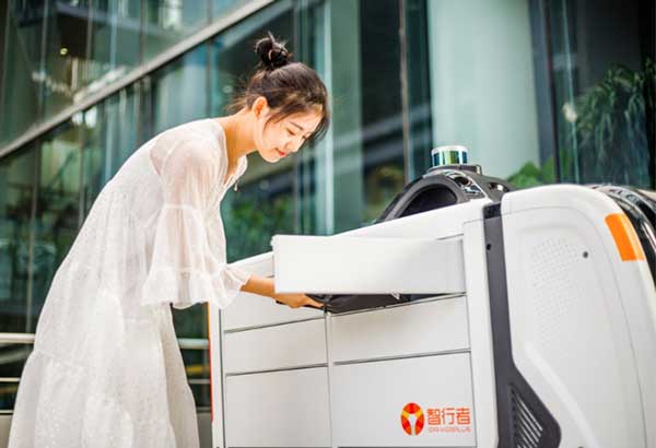 A customer removes her express package from the Wobida logistics vehicle. (Photo: Unicore)