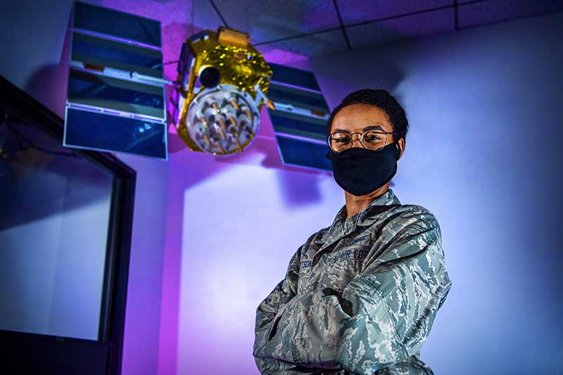 First Lt. Mikayla Roberts, 2nd Space Operations Squadron mission analyst, poses with a model satellite July 23, 2020, at Schriever Air Force Base, Colorado. Roberts was one of eight women who worked on the historic all-female crew. (U.S. Air Force photo by Dennis Rogers and Kathryn Damon)