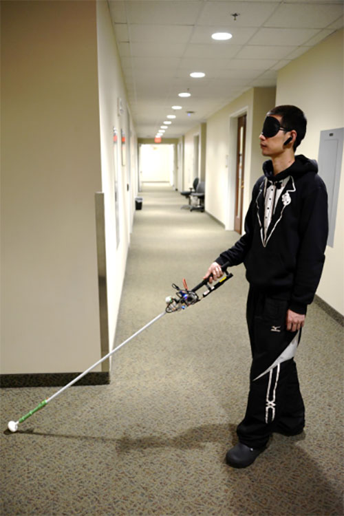 Study author Lingqiu Jin tests the robotic cane. (Photo: Cang Ye, VCU/NIH)