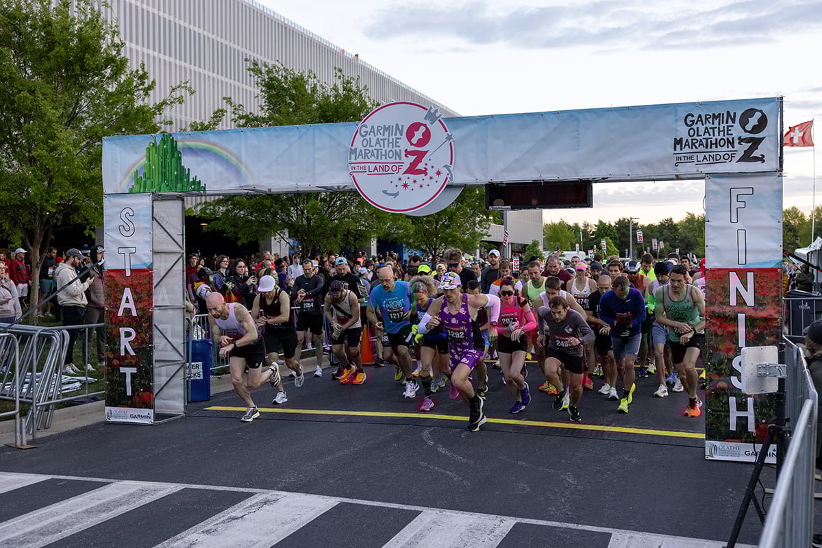 The 2024 Garmin Olathe Marathon kicks off as dozens of runners a the front begin running across the starting line.