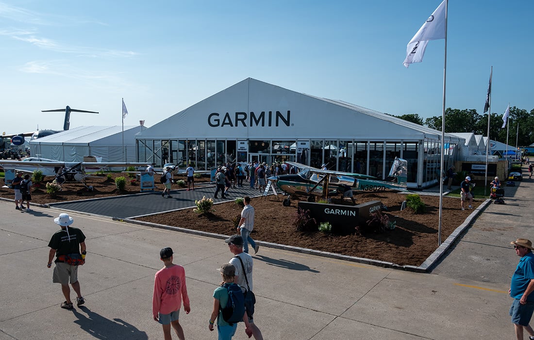 The Garmin booth, which contains small airplanes, Garmin products, event attendees and Garmin associates, is set up at a previous Oshkosh event at the Wittman Regional Airport in Oshkosh, Wisconsin.