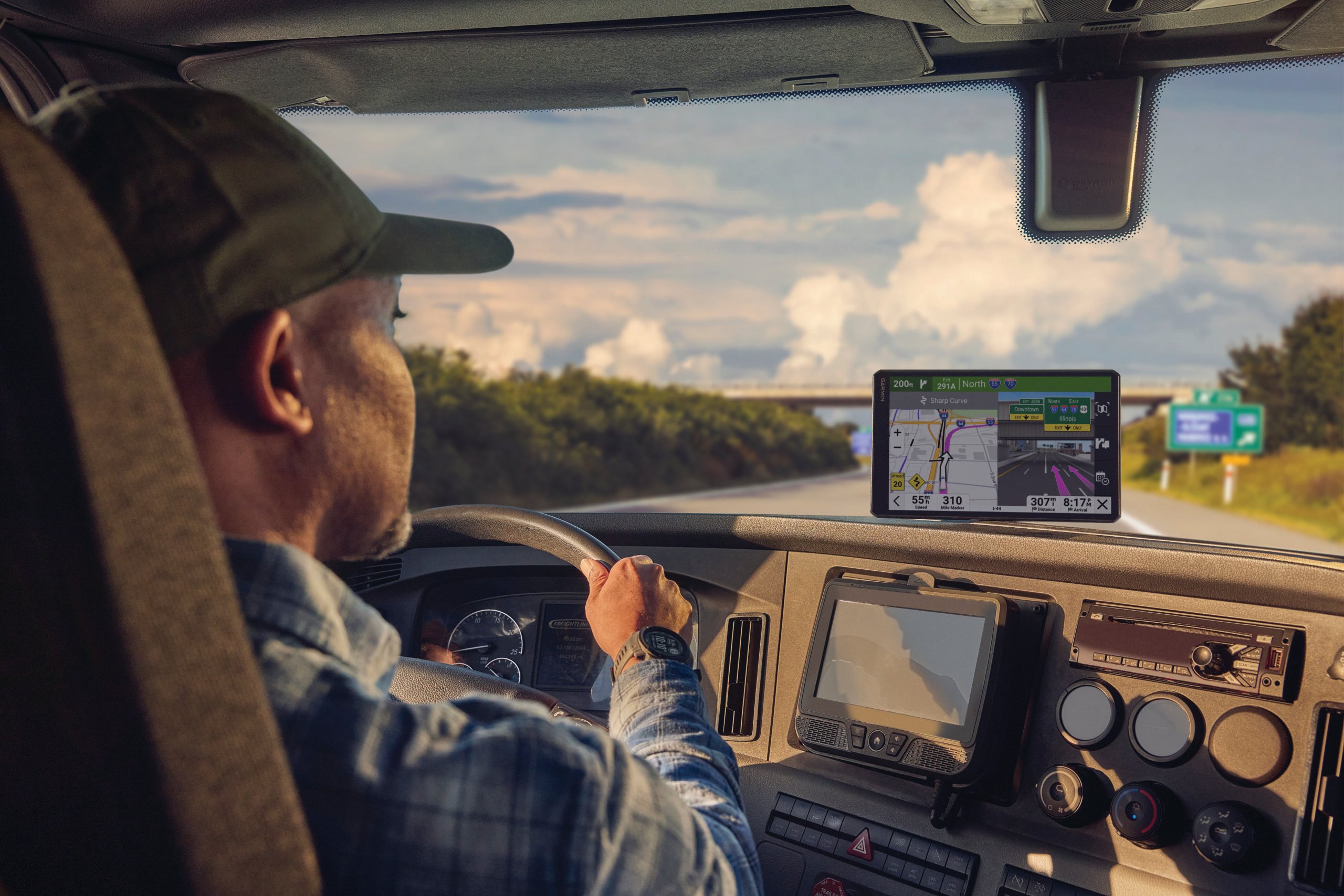 Truck driver looking at his truck navigator for directions.